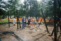 Group of Volunteers Carrying a Curved Metal Pole