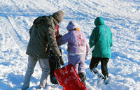 Family Climbing Back Up Hill to Sled